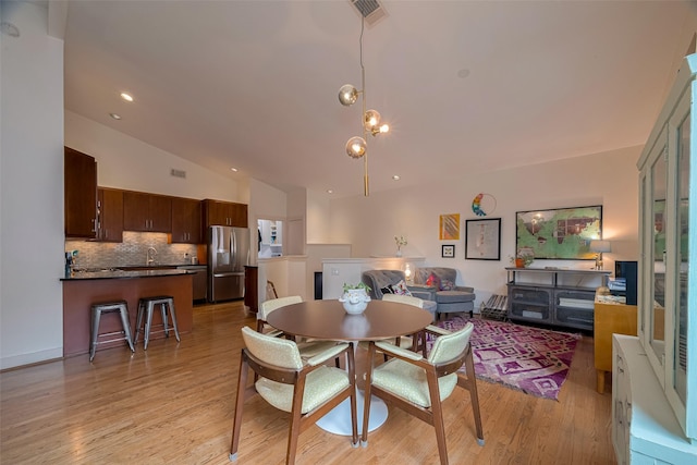 308 Dennis St, Houston, TX 77006 - dining room featuring vaulted ceiling and light wood-type flooring