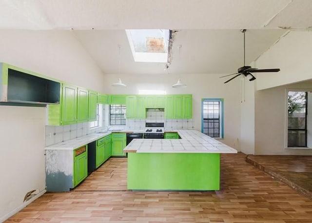 222 E Southland Ave, Alvin, TX 77511 - kitchen featuring green cabinetry, range, light wood-type flooring, backsplash, and tile counters