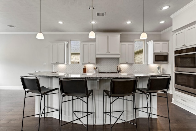 13819 Windward Harbor Ct, Houston, TX 77059 - kitchen with stainless steel appliances, backsplash, white cabinetry, a center island with sink, and crown molding