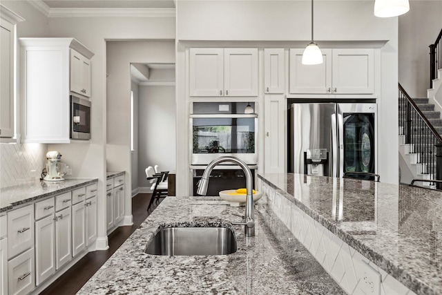 13819 Windward Harbor Ct, Houston, TX 77059 - kitchen featuring stainless steel appliances, white cabinetry, crown molding, dark wood-type flooring, and hanging light fixtures
