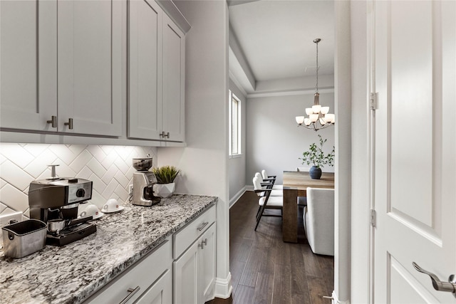 13819 Windward Harbor Ct, Houston, TX 77059 - kitchen with a chandelier, decorative backsplash, dark wood-type flooring, light stone countertops, and decorative light fixtures