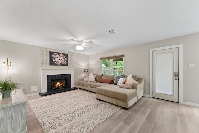 3715 Ember Spring Dr, Kingwood, TX 77339 - living area featuring a ceiling fan, light wood finished floors, and a brick fireplace
