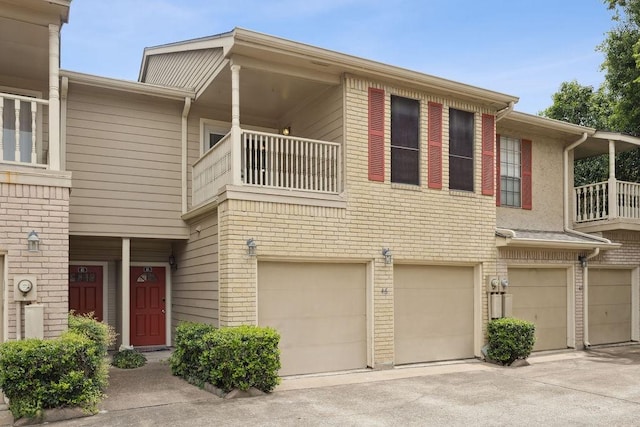 7350 Kirby Dr Unit 46, Houston, TX 77030 - view of front of property featuring a balcony, an attached garage, and driveway