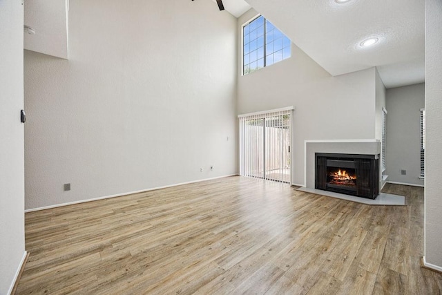 7350 Kirby Dr Unit 46, Houston, TX 77030 - unfurnished living room featuring wood finished floors, a warm lit fireplace, and a towering ceiling