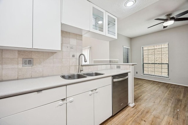 7350 Kirby Dr Unit 46, Houston, TX 77030 - kitchen with dishwasher, light countertops, white cabinetry, backsplash, and a textured ceiling