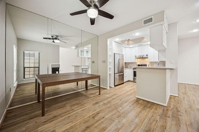 7350 Kirby Dr Unit 46, Houston, TX 77030 - kitchen featuring appliances with stainless steel finishes, a ceiling fan, white cabinetry, backsplash, and light countertops