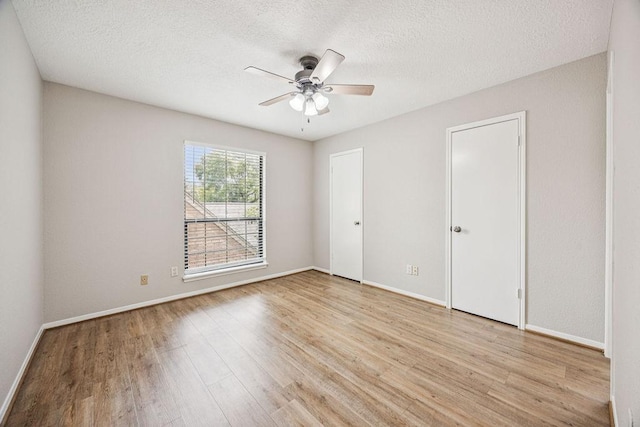 7350 Kirby Dr Unit 46, Houston, TX 77030 - unfurnished bedroom with light wood-type flooring, a textured ceiling, and a ceiling fan
