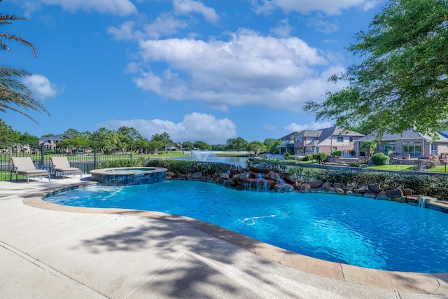 8411 Middle Canyon Rd, Katy, TX 77494 - view of swimming pool featuring a pool with connected hot tub, a water view, and a patio area