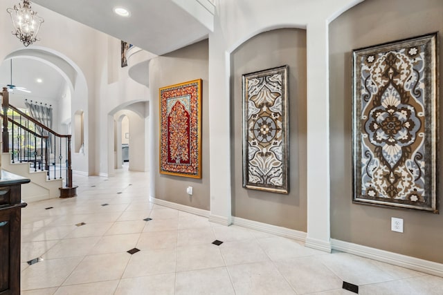 8411 Middle Canyon Rd, Katy, TX 77494 - entrance foyer with light tile patterned floors, arched walkways, stairs, and recessed lighting