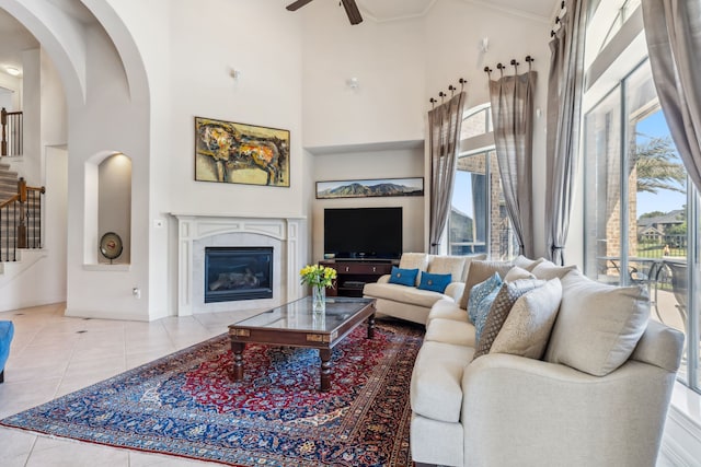 8411 Middle Canyon Rd, Katy, TX 77494 - living room with a high ceiling, stairs, tile patterned floors, ceiling fan, and a premium fireplace