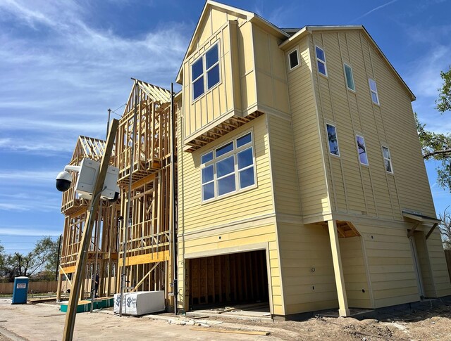 1739 Mary St, Houston, TX 77026 - view of property exterior with an attached garage, stairs, and board and batten siding