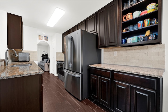 1860 White Oak Dr Unit 251, Houston, TX 77009 - kitchen featuring freestanding refrigerator, arched walkways, decorative backsplash, dark brown cabinets, and open shelves
