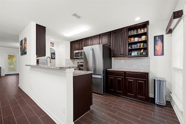 1860 White Oak Dr Unit 251, Houston, TX 77009 - kitchen with appliances with stainless steel finishes, dark brown cabinets, decorative backsplash, wood tiled floors, and recessed lighting