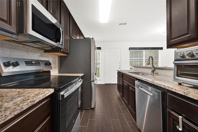 1860 White Oak Dr Unit 251, Houston, TX 77009 - kitchen featuring appliances with stainless steel finishes, light stone counters, and dark brown cabinets