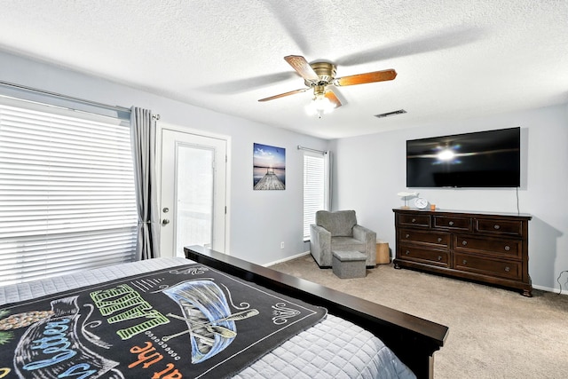 100 Edgewater Dr Unit 39, Livingston, TX 77351 - carpeted bedroom featuring multiple windows, ceiling fan, and a textured ceiling