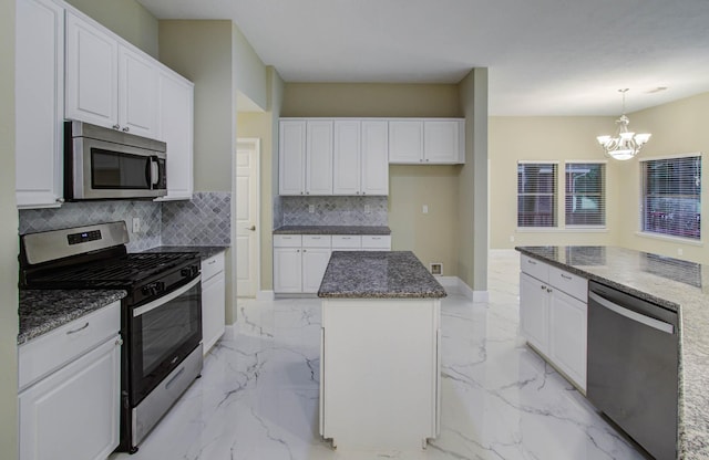 18327 Bluewater Cove Dr, Humble, TX 77346 - kitchen with appliances with stainless steel finishes, a chandelier, a kitchen island, decorative backsplash, and white cabinetry