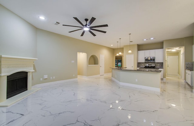 18327 Bluewater Cove Dr, Humble, TX 77346 - unfurnished living room featuring light marble finish flooring, a ceiling fan, a fireplace with raised hearth, and recessed lighting