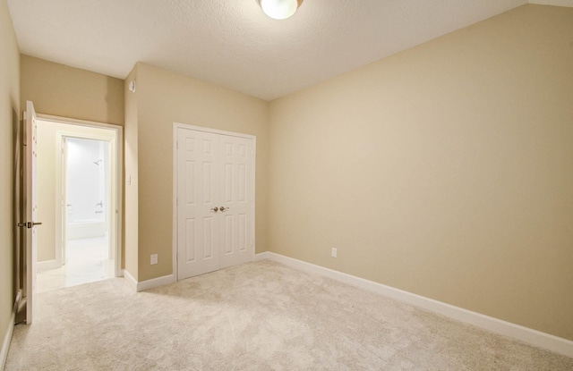 18327 Bluewater Cove Dr, Humble, TX 77346 - unfurnished bedroom featuring light colored carpet, a closet, and a textured ceiling