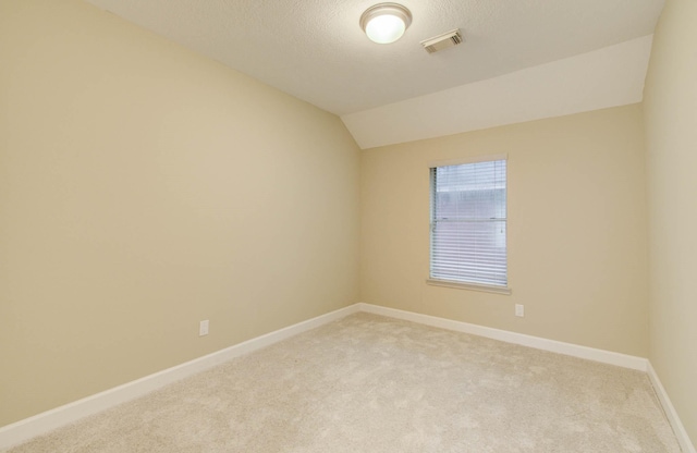 18327 Bluewater Cove Dr, Humble, TX 77346 - empty room featuring light colored carpet, lofted ceiling, and a textured ceiling