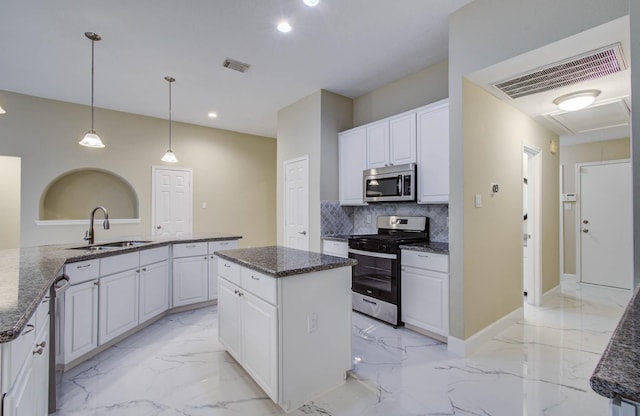 18327 Bluewater Cove Dr, Humble, TX 77346 - kitchen featuring stainless steel appliances, light marble finish floors, a kitchen island, white cabinets, and tasteful backsplash