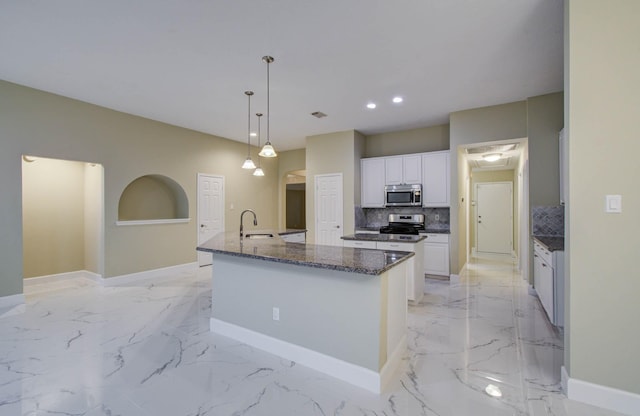 18327 Bluewater Cove Dr, Humble, TX 77346 - kitchen featuring stainless steel appliances, an island with sink, light marble finish flooring, decorative backsplash, and white cabinets