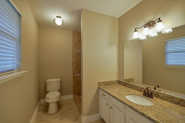 2903 Valley Rose Dr, Kingwood, TX 77339 - bathroom featuring vanity, tiled shower, tile patterned flooring, healthy amount of natural light, and a textured ceiling