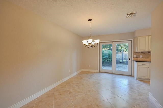 2903 Valley Rose Dr, Kingwood, TX 77339 - unfurnished dining area featuring a chandelier, a textured ceiling, and light tile patterned floors