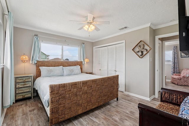 4004 Ector Dr, Galveston, TX 77554 - bedroom with a closet, wood finished floors, ornamental molding, and ceiling fan