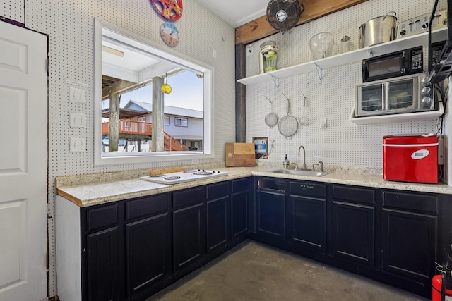 4004 Ector Dr, Galveston, TX 77554 - kitchen with unfinished concrete flooring, open shelves, white stovetop, light countertops, and dark cabinetry
