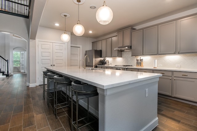 21207 Bradford Grove Dr, Spring, TX 77379 - kitchen featuring gray cabinetry, arched walkways, dark wood-style floors, and recessed lighting