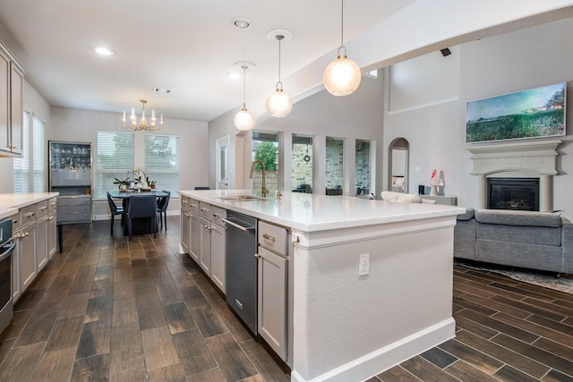 21207 Bradford Grove Dr, Spring, TX 77379 - kitchen featuring a chandelier, dark wood-style flooring, dishwasher, light countertops, and a glass covered fireplace