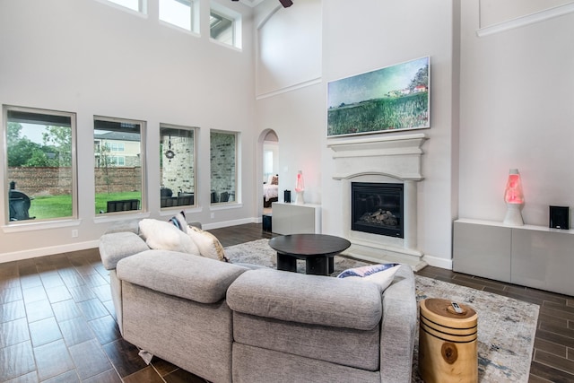 21207 Bradford Grove Dr, Spring, TX 77379 - living area featuring a high ceiling, dark wood finished floors, arched walkways, and a glass covered fireplace