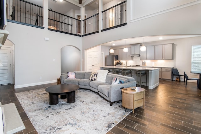 21207 Bradford Grove Dr, Spring, TX 77379 - living area with arched walkways, wood tiled floors, a high ceiling, and recessed lighting