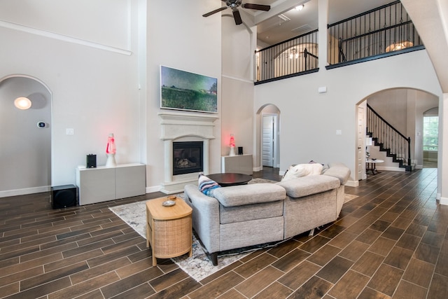 21207 Bradford Grove Dr, Spring, TX 77379 - living area featuring arched walkways, ceiling fan, wood tiled floors, a high ceiling, and a glass covered fireplace