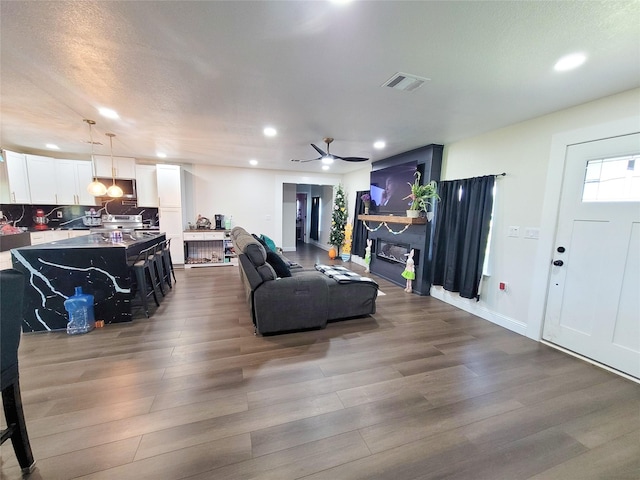 606 E Ahldag St, Wharton, TX 77488 - living room featuring a ceiling fan, recessed lighting, dark wood-type flooring, and a glass covered fireplace