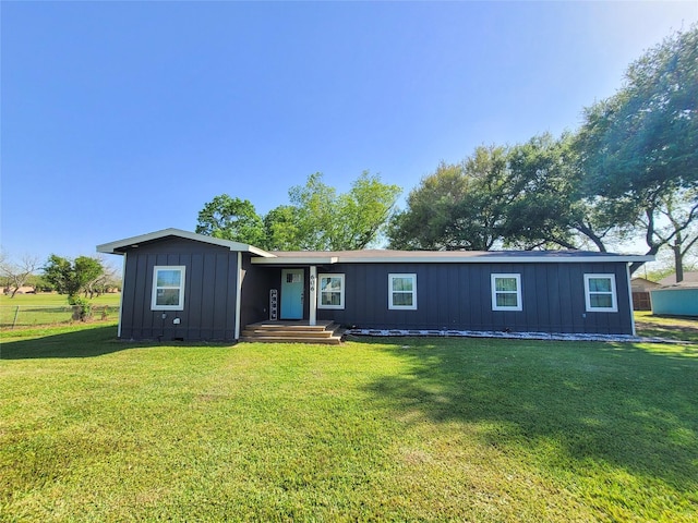 606 E Ahldag St, Wharton, TX 77488 - view of front facade with board and batten siding and a front lawn