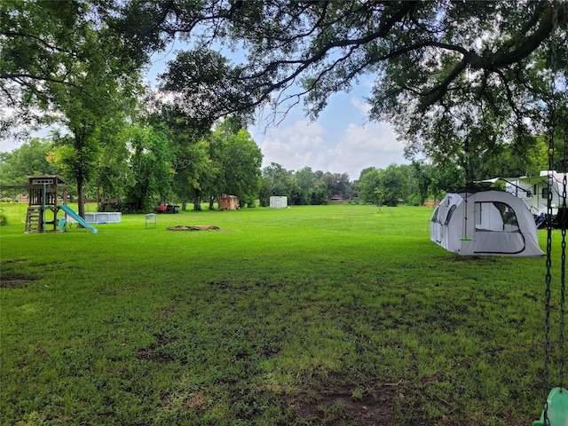 606 E Ahldag St, Wharton, TX 77488 - view of grassy yard with a playground and a storage unit
