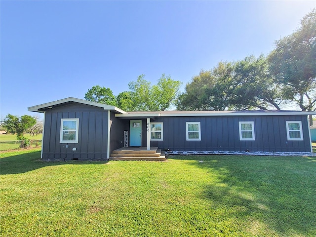 606 E Ahldag St, Wharton, TX 77488 - view of front of home featuring board and batten siding and a front lawn