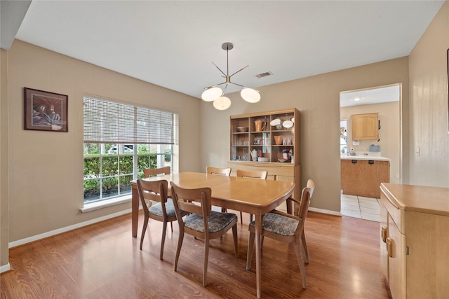 7615 Sandygate Ln, Houston, TX 77095 - dining space with light wood-style floors and a chandelier