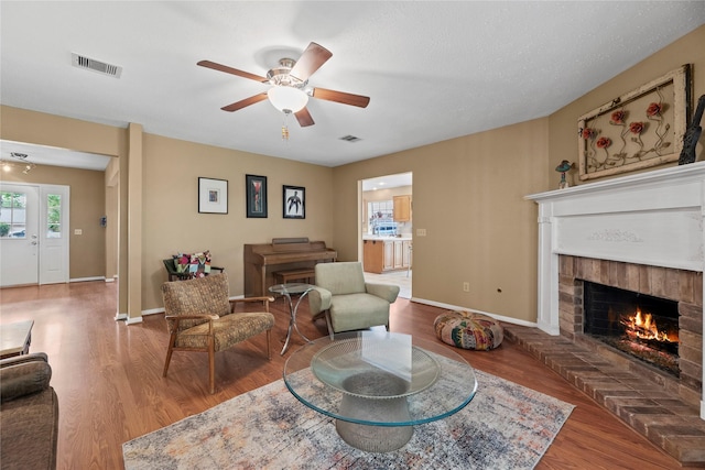 7615 Sandygate Ln, Houston, TX 77095 - living room featuring a brick fireplace, wood finished floors, and a ceiling fan