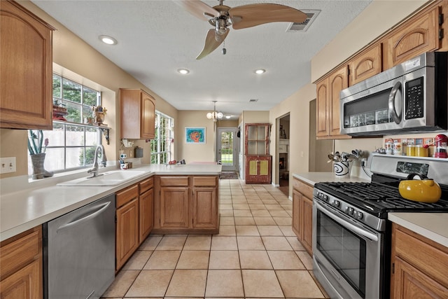 7615 Sandygate Ln, Houston, TX 77095 - kitchen featuring appliances with stainless steel finishes, light countertops, a peninsula, ceiling fan, and a chandelier