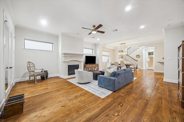 961 Queen Annes Rd, Houston, TX 77024 - living room featuring stairs, crown molding, a glass covered fireplace, wood-type flooring, and ceiling fan