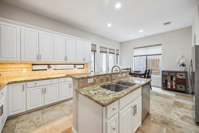 961 Queen Annes Rd, Houston, TX 77024 - kitchen featuring decorative backsplash, a kitchen island with sink, appliances with stainless steel finishes, white cabinetry, and recessed lighting