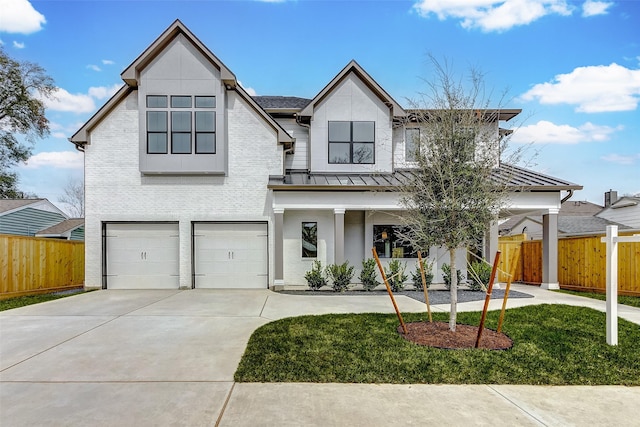 6522 Westview Dr, Houston, TX 77055 - view of front facade featuring a standing seam roof, driveway, a garage, brick siding, and a metal roof