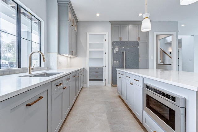 6522 Westview Dr, Houston, TX 77055 - kitchen featuring stainless steel microwave, gray cabinetry, pendant lighting, recessed lighting, and light stone counters