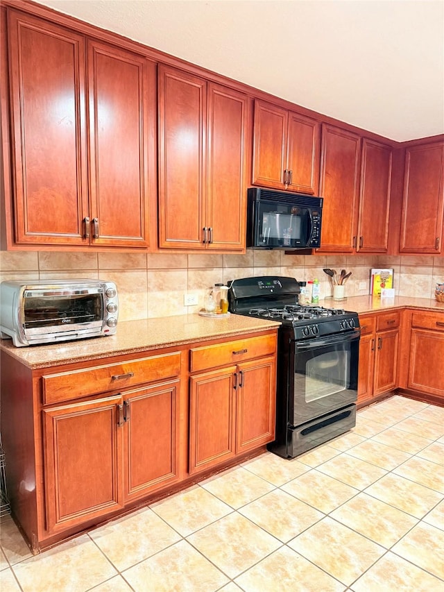 14022 Blackfoot Trail Run, Cypress, TX 77429 - kitchen with black appliances, light stone counters, dark brown cabinets, and light tile patterned floors