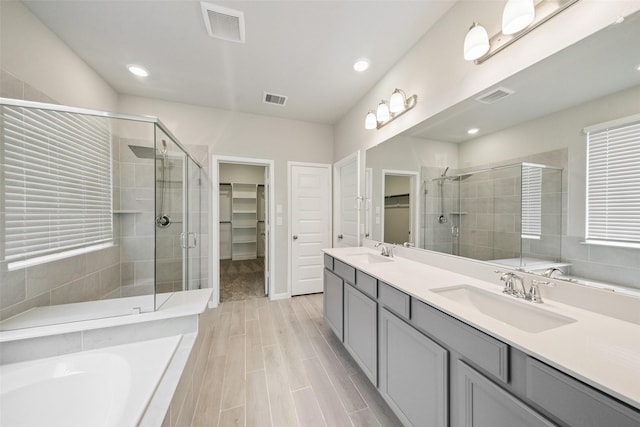 4805 Magnolia Springs Dr, Pearland, TX 77584 - bathroom with a walk in closet, a stall shower, double vanity, a garden tub, and recessed lighting