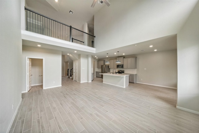 4805 Magnolia Springs Dr, Pearland, TX 77584 - unfurnished living room featuring stairs, light wood finished floors, a towering ceiling, and recessed lighting