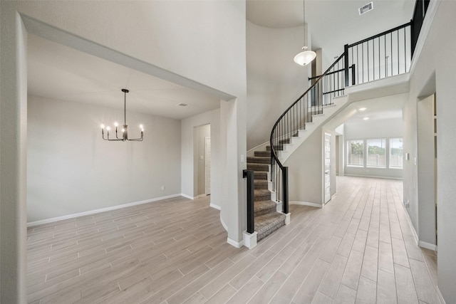 4805 Magnolia Springs Dr, Pearland, TX 77584 - foyer with a chandelier, light wood finished floors, stairs, and a towering ceiling