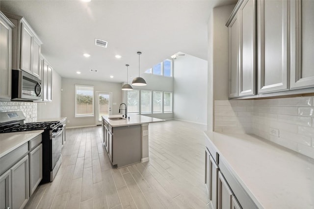 4805 Magnolia Springs Dr, Pearland, TX 77584 - kitchen with stainless steel appliances, light countertops, recessed lighting, light wood-type flooring, and a kitchen island with sink